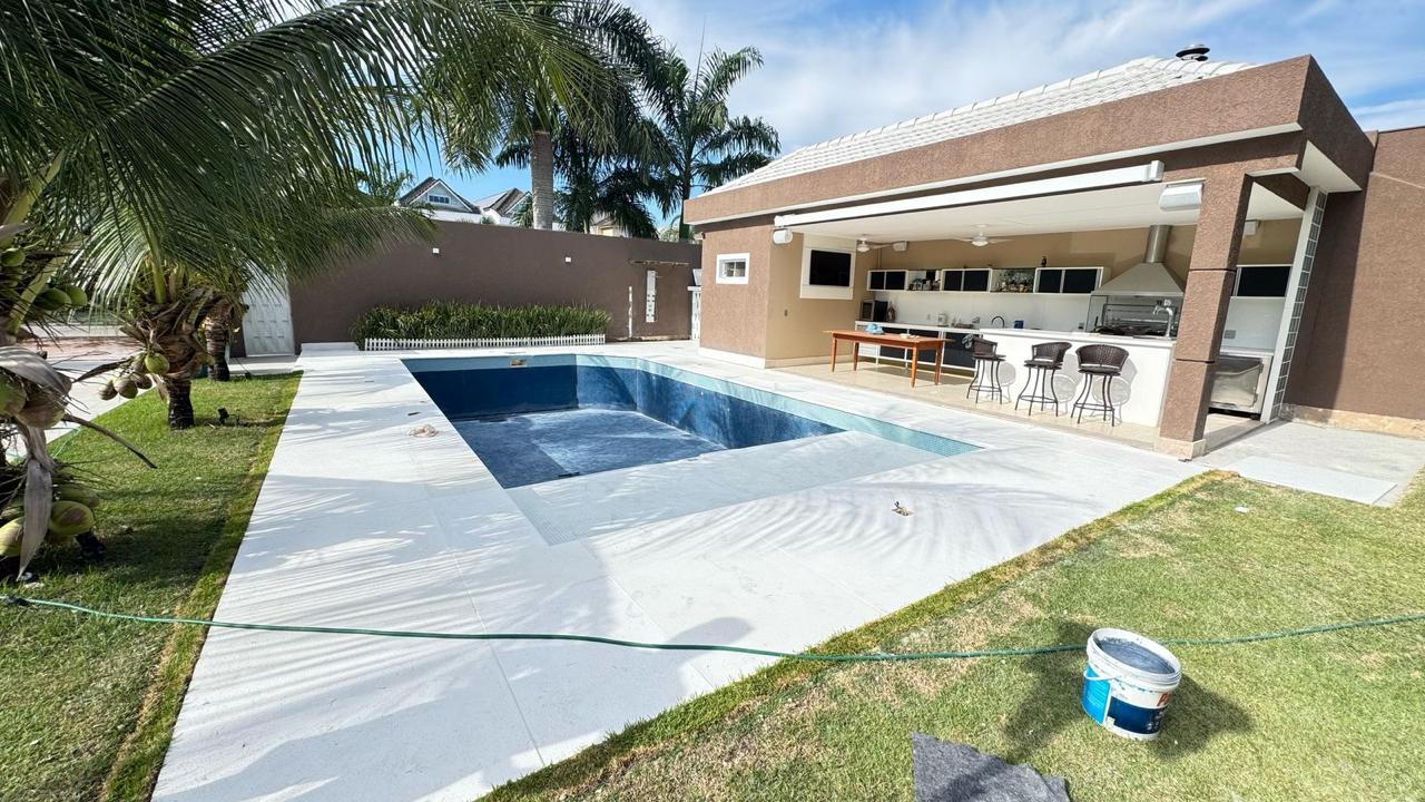 Piscina residencial com piso atérmico claro e área gourmet integrada